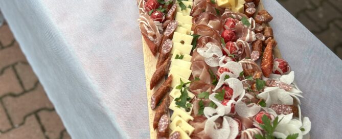 Eine reichlich belegte Vesper-Platte mit Wurst und Käse sowie Radi steht auf dem Tisch.